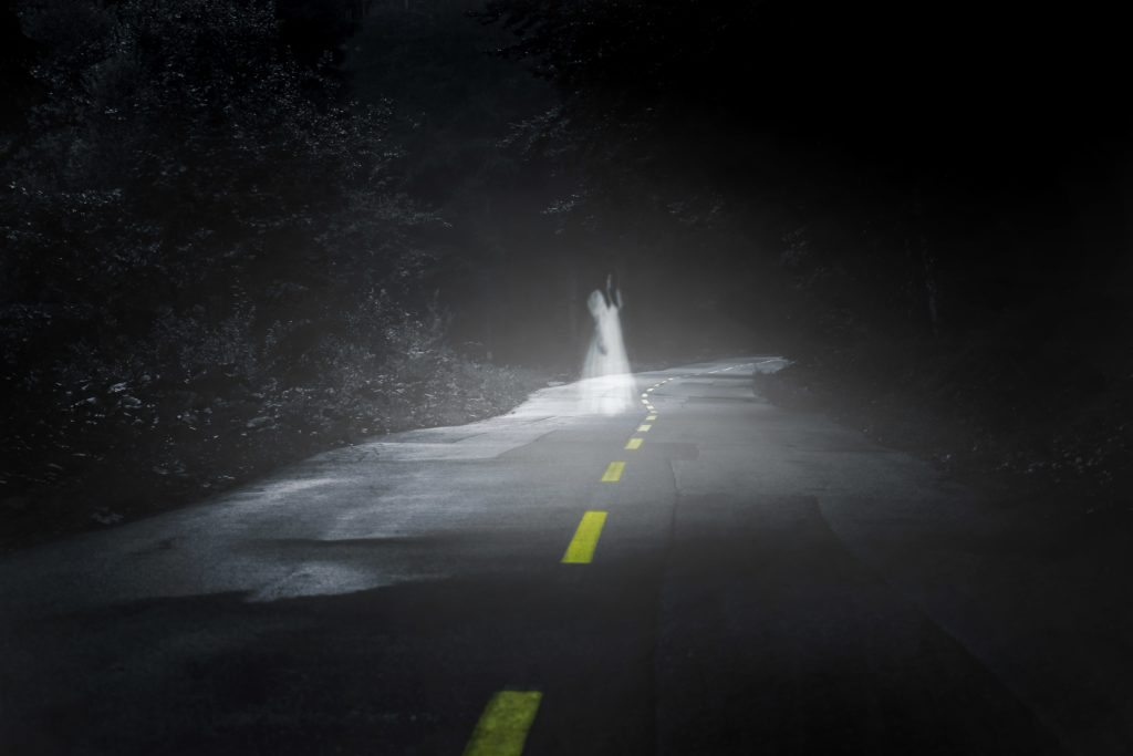 a ghostly figure of a girl in the middle of the road