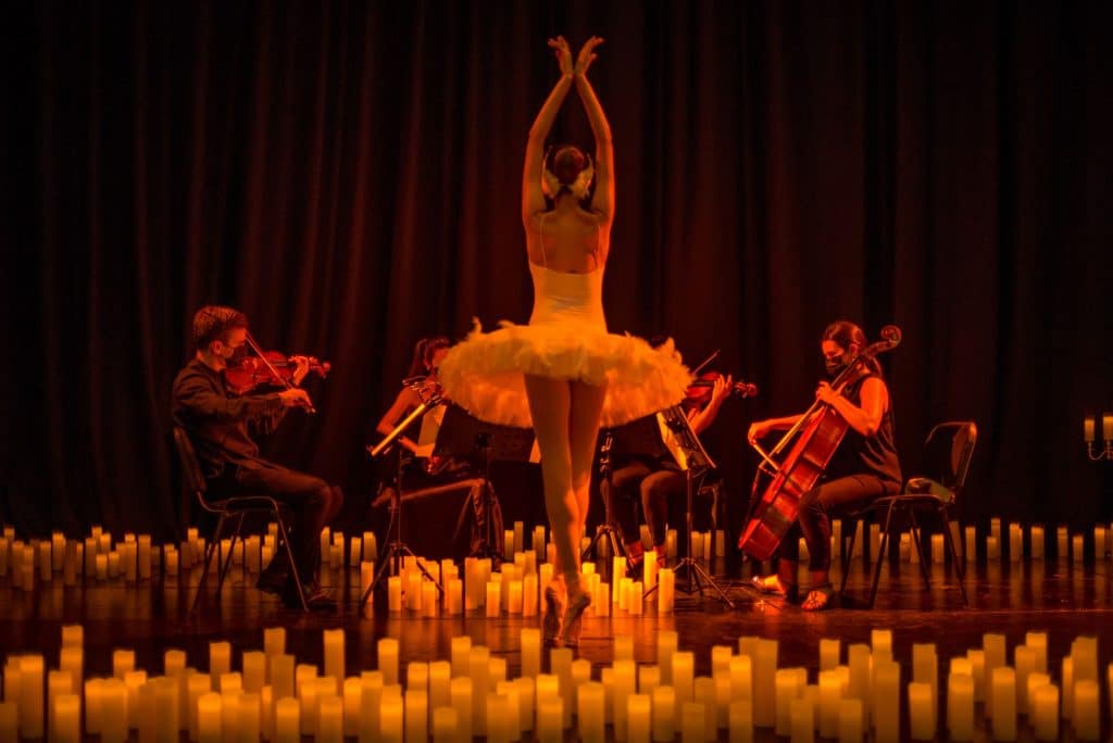 ballerina surrounded by candles in front of string quartet