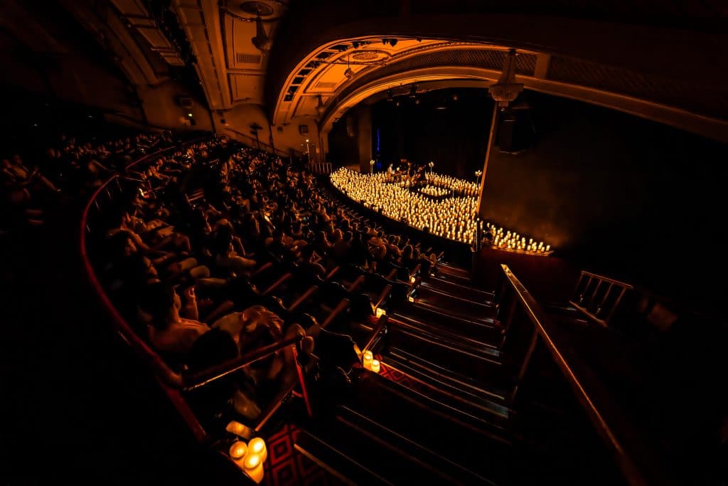 candlelight concert at vintage theatre with candles on stage surrounding performers