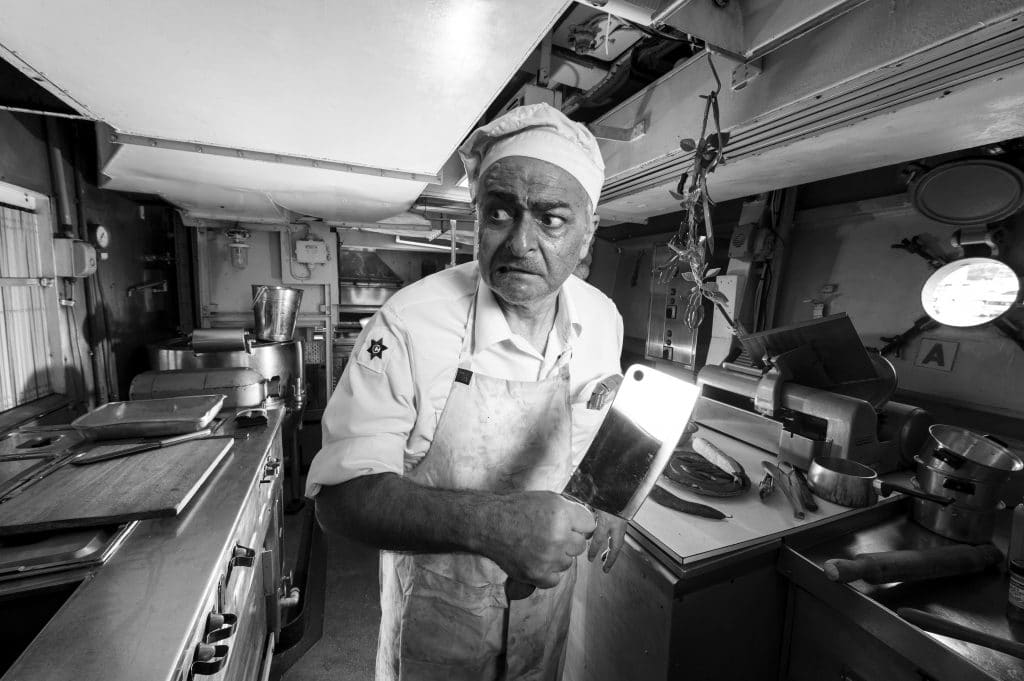 ship cook weilding large knife looking afraid