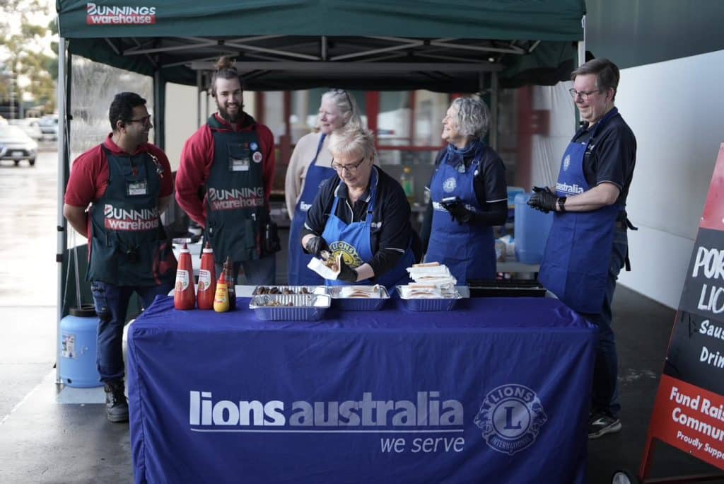 Lions community group members at sausage sizzle with bunnings staff