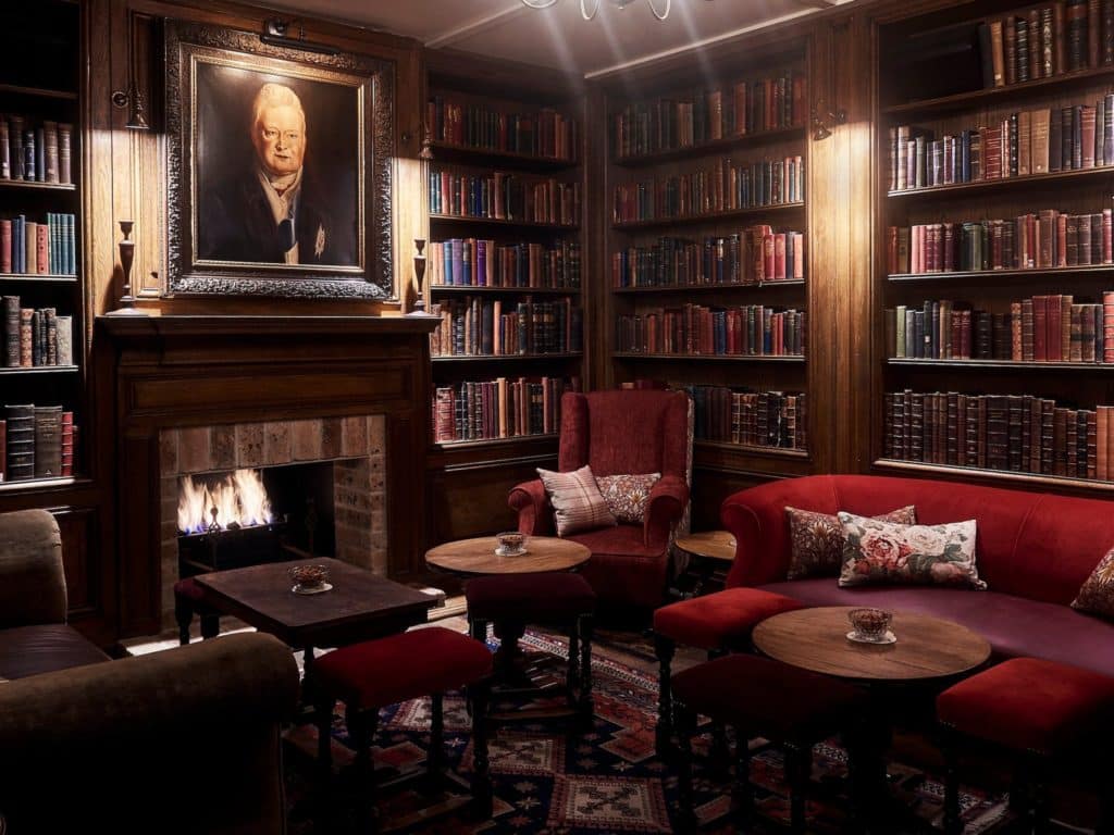 a dimly lit pub with a fireplace and books