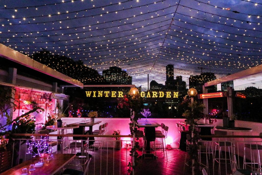 winter garden rooftop at east village sydney decorated with fairy lights, pink lighting and heaters