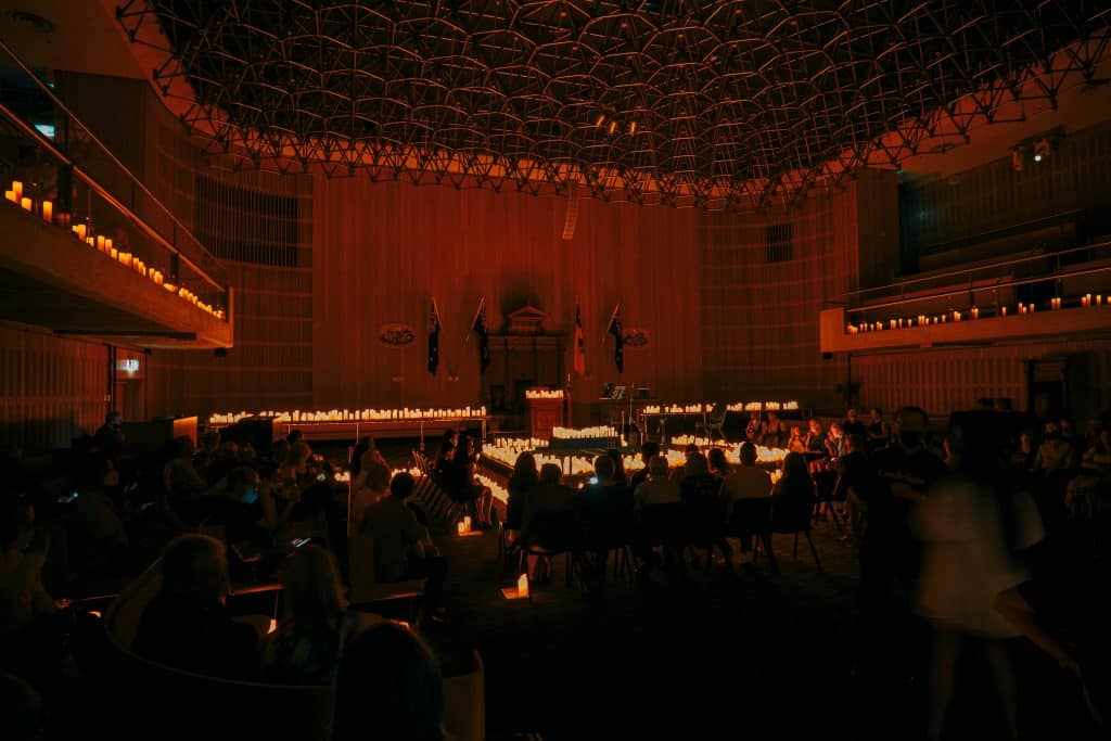 the grand hall of the sydney masonic centre lit up with candlelight showcasing the extravangantly designed ceiling and string quartet perfporming vivaldi on stage