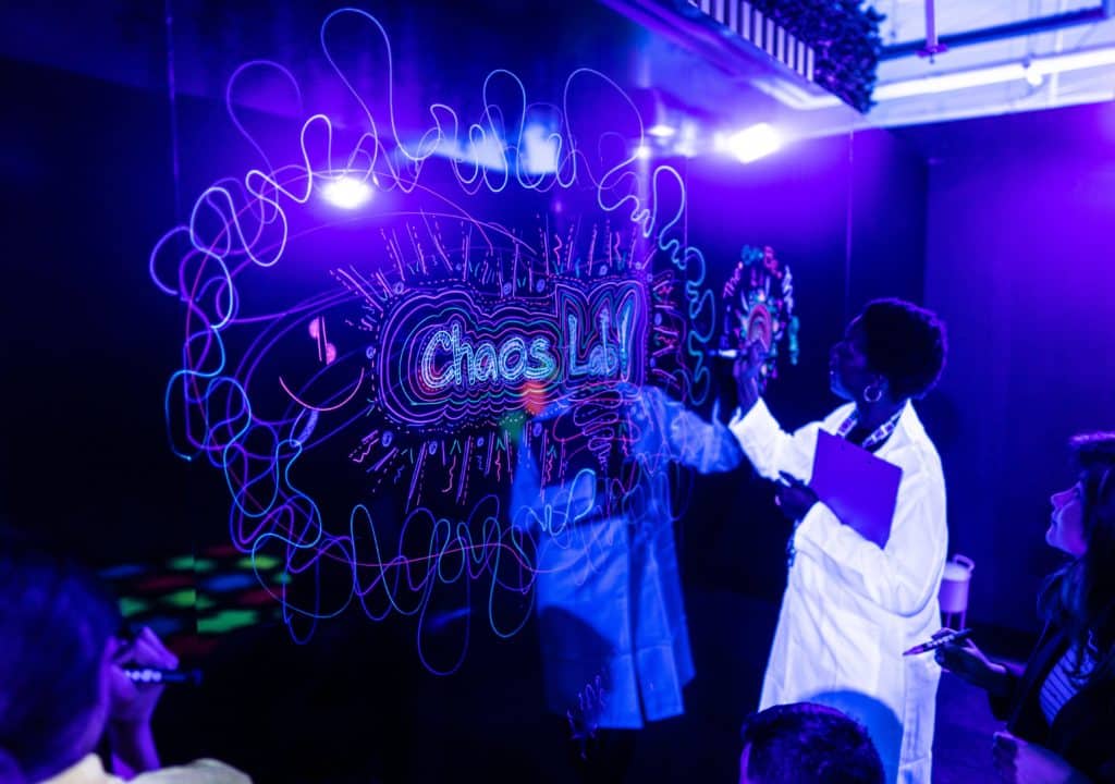 children science lab with scientist with neon writing on some kind of glass wall at chaos lab sydney