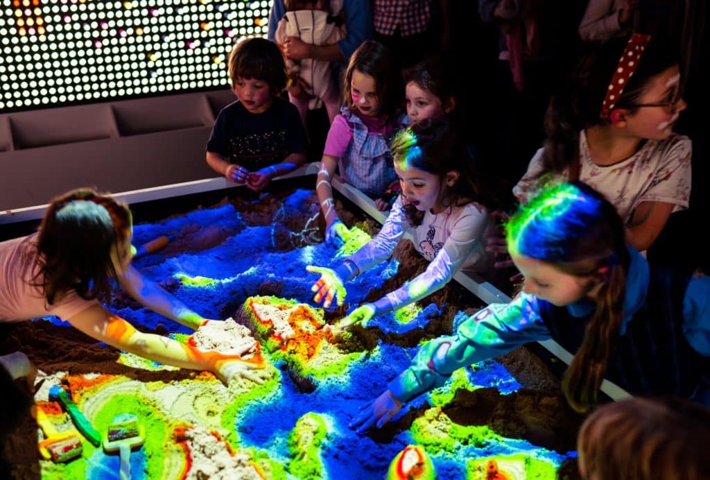 kids playing on interactive and illuminated sandpit at chaos lab