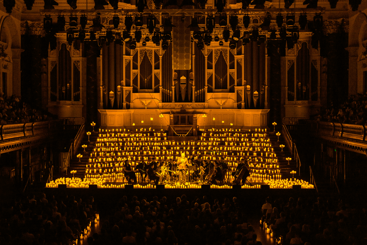 The stage at Sydney Town Hall covered in hundreds of candles surrounding a string quartet.