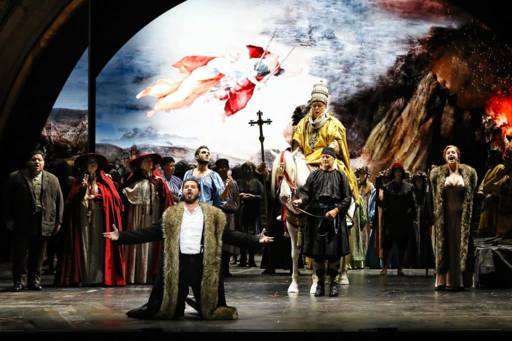 performance on stage of attila opera with actor on knees and another on a horse