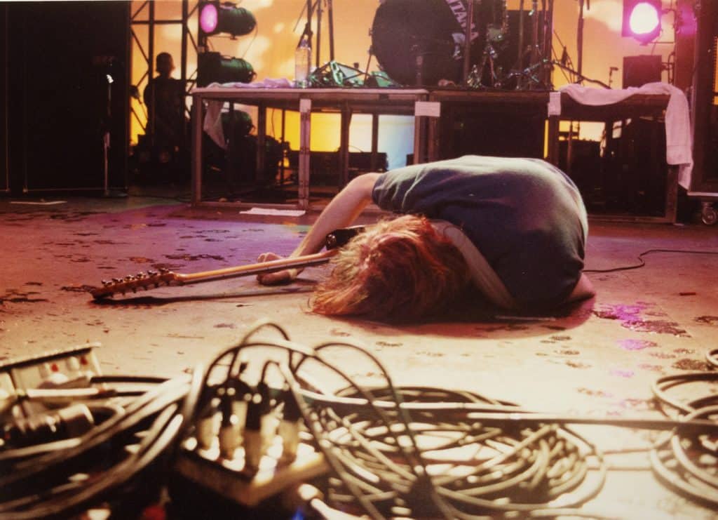kurt cobain with his guitar on the stage floor of the horden pavillion in sydney, image as part of exhibition