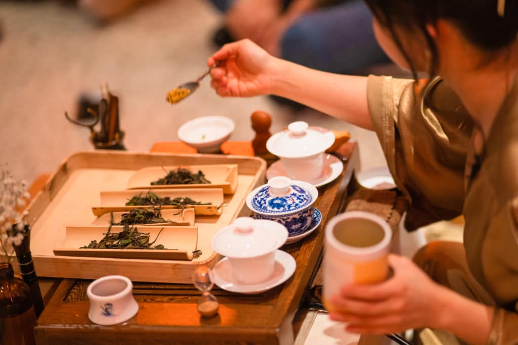 altitude tea tea ceremony with person spooning tea leaves