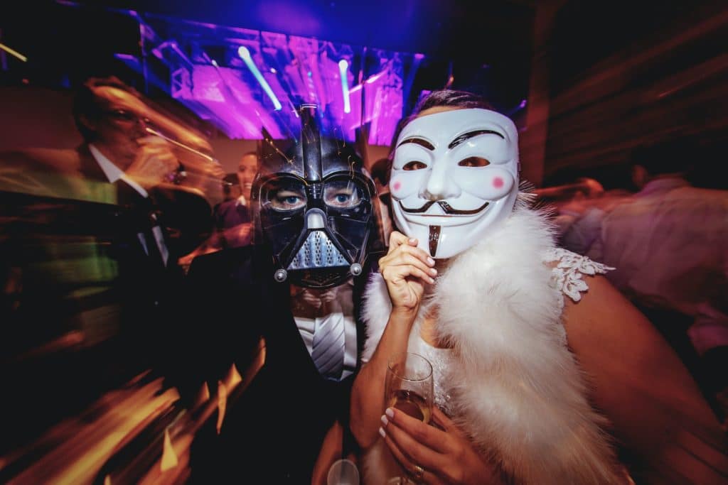 two people wearing masks, darth vader and guy fawkes mask