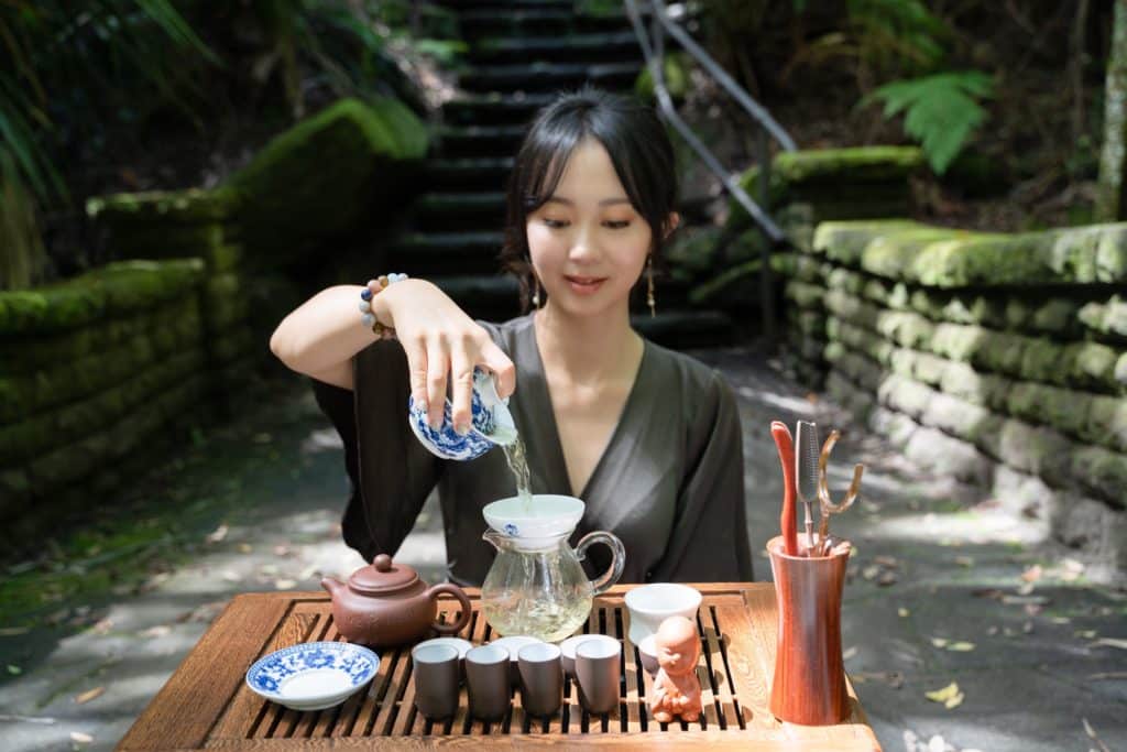 young woman conducting a tea ceremony in a garden