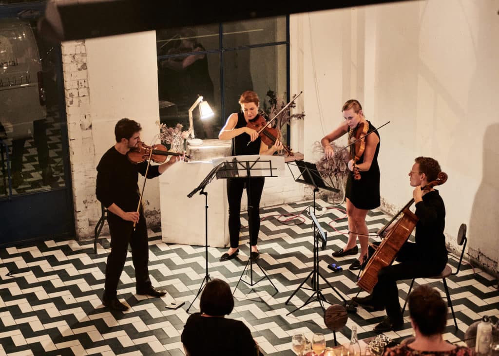 Nomad String Quartet performing on a tiled floor 