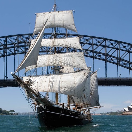 Tall ship with white sails sailing in the Sydney harbour
