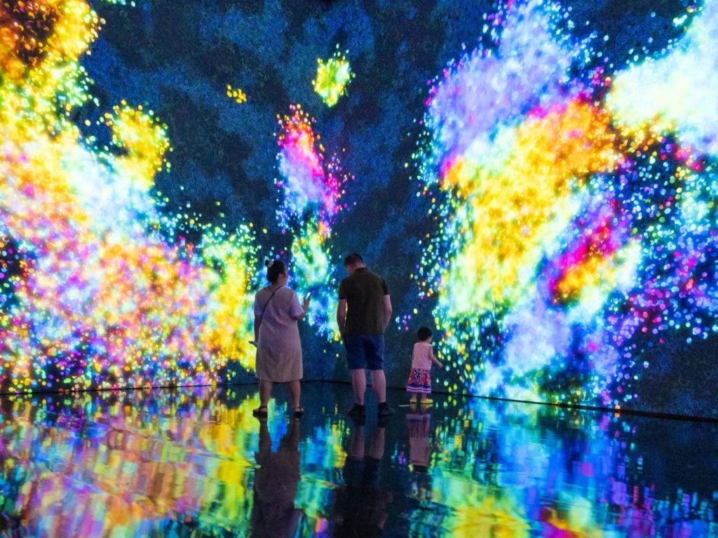 family of three in front of art-tech projection of colours in singapore