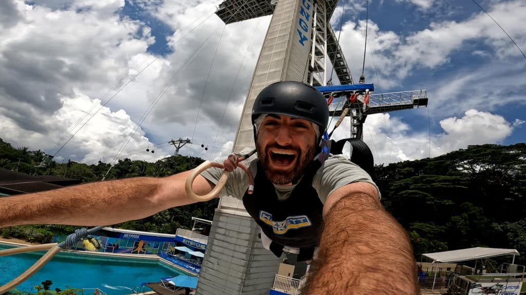 man in mid air selfie bungee jumping on sentosa island in singapore