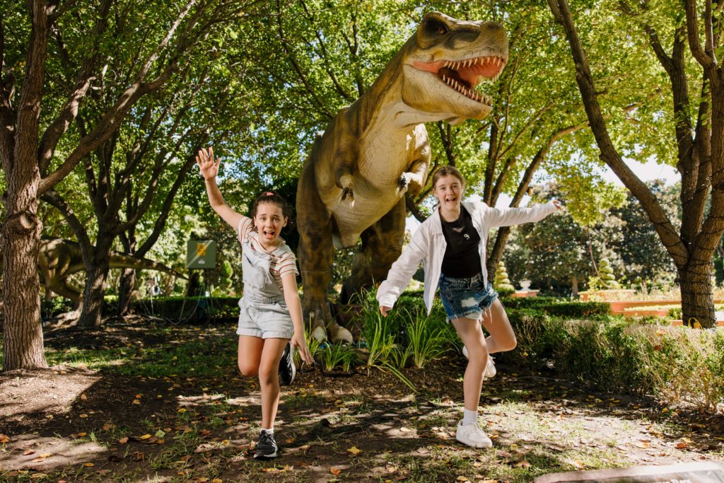 children being chased by an animatronic dinosaur 