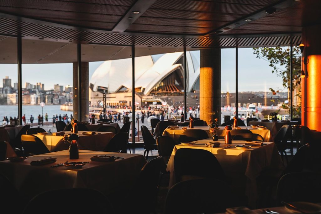 a restaurant with dim lighting overlooking the opera house