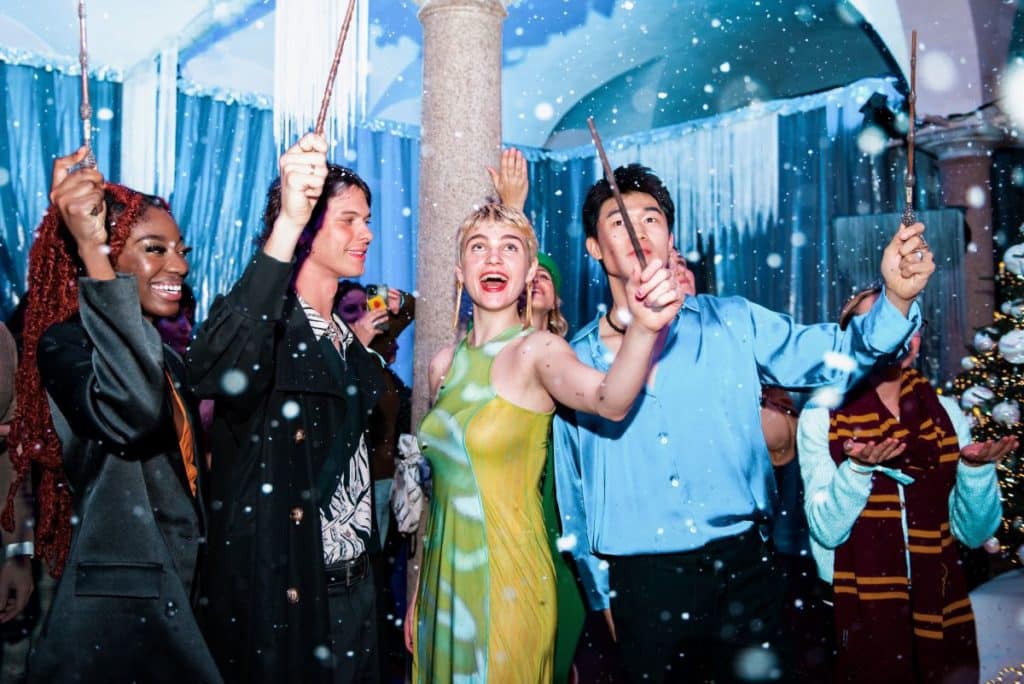 Guests wave wands in the air amongst snow flurries at Harry Potter: A Yule Ball Celebration.