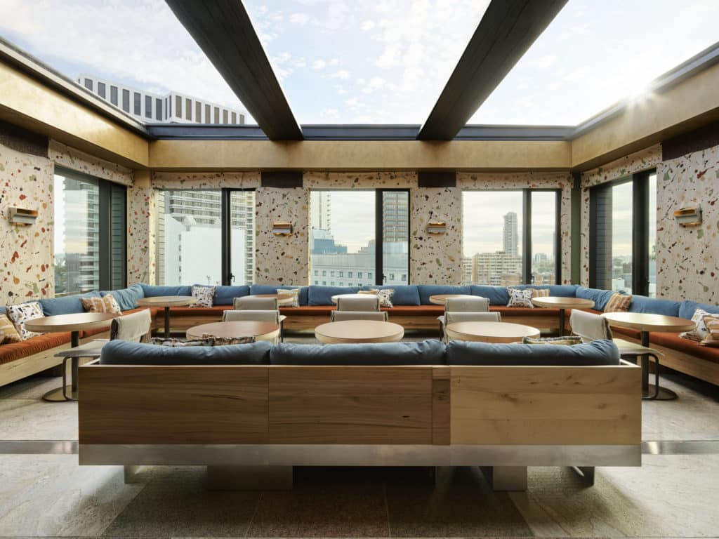 a rooftop bar with glass ceilings, sofas and chairs 