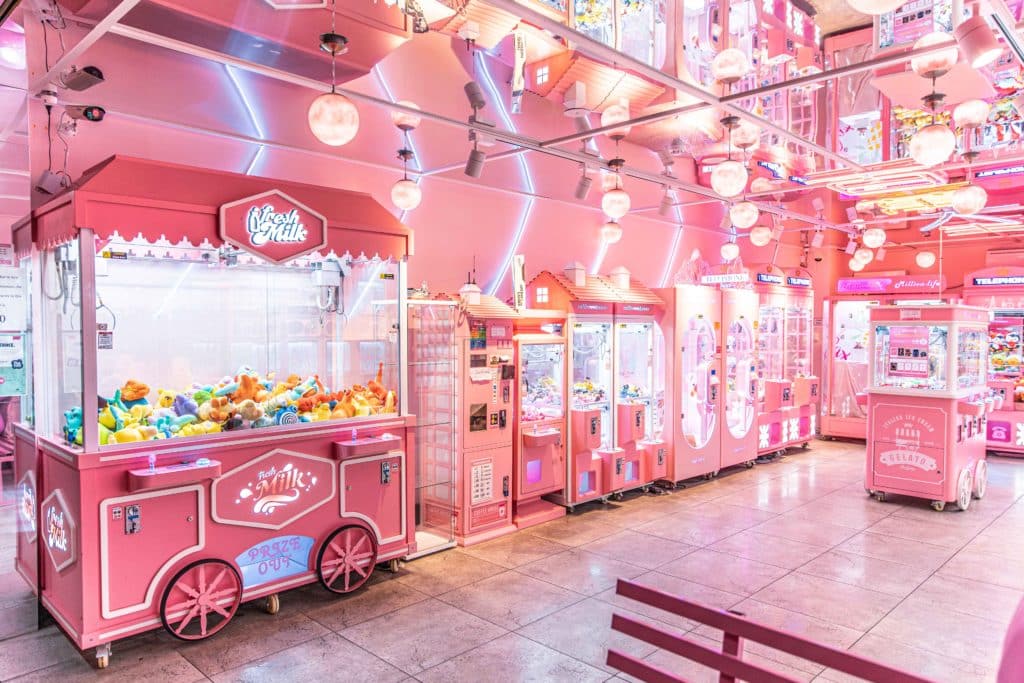 an all-pink arcade with gaming consoles and toys