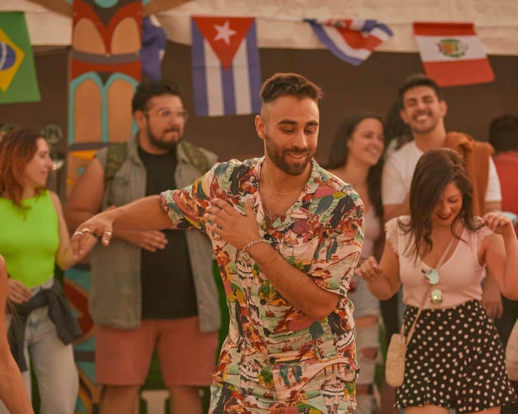A man in a floral shirt dances at Ritmo Latino festival.