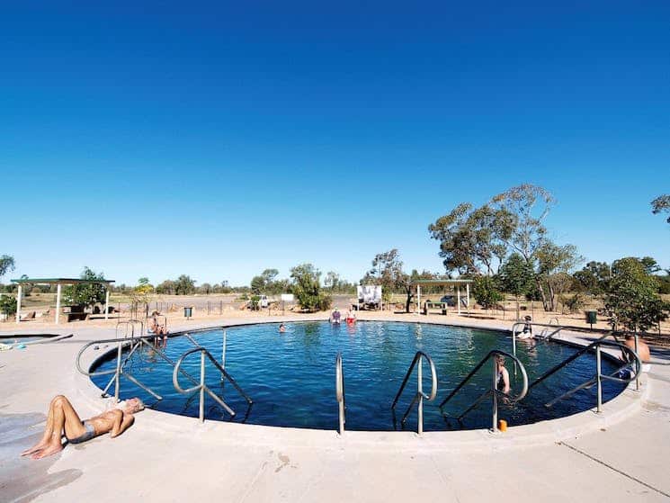 people lounging and swimming at the Lightning Ridge Bore Baths