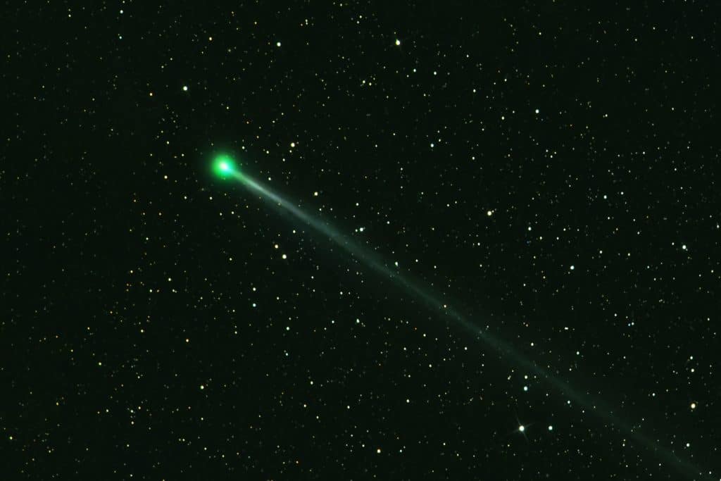a green comet in the night sky