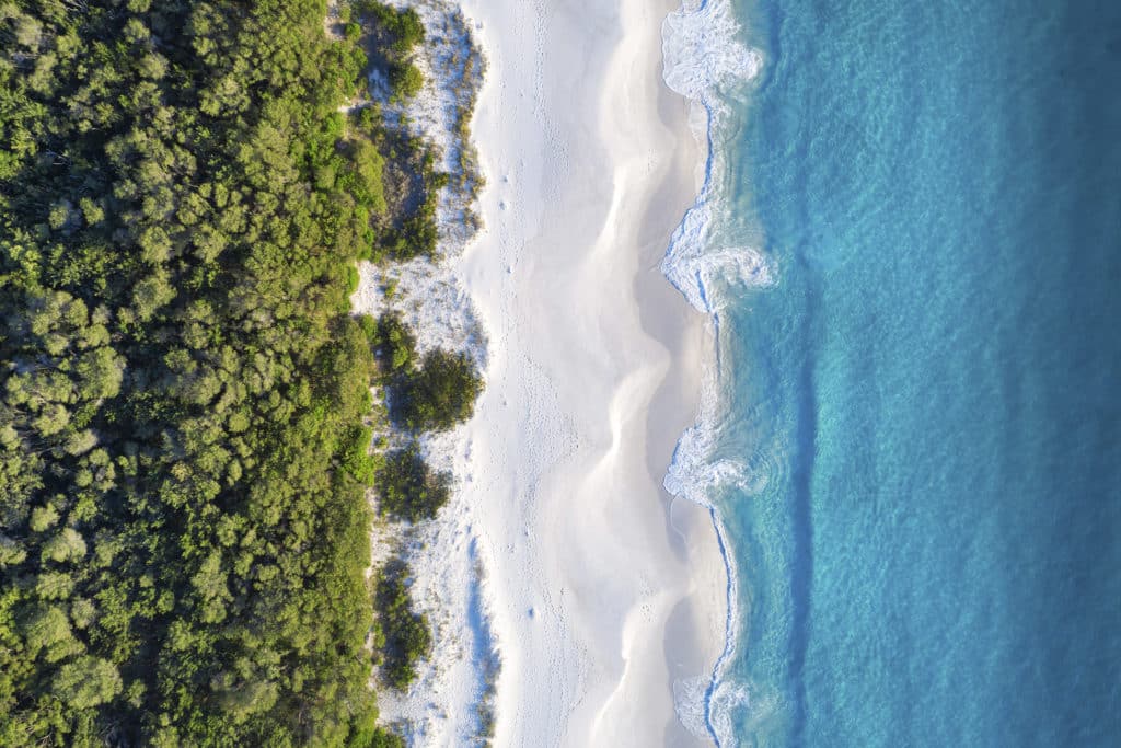 Aerial overlooking the white sands of Hyams Beach, Jervis Bay.